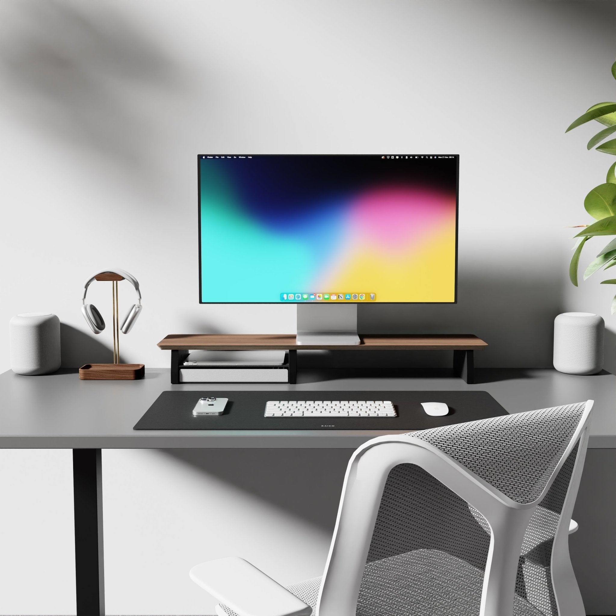 medium sized Raico desk shelf with large leather desk mat and a walnut headphone on the side. Overall a modern desk setup